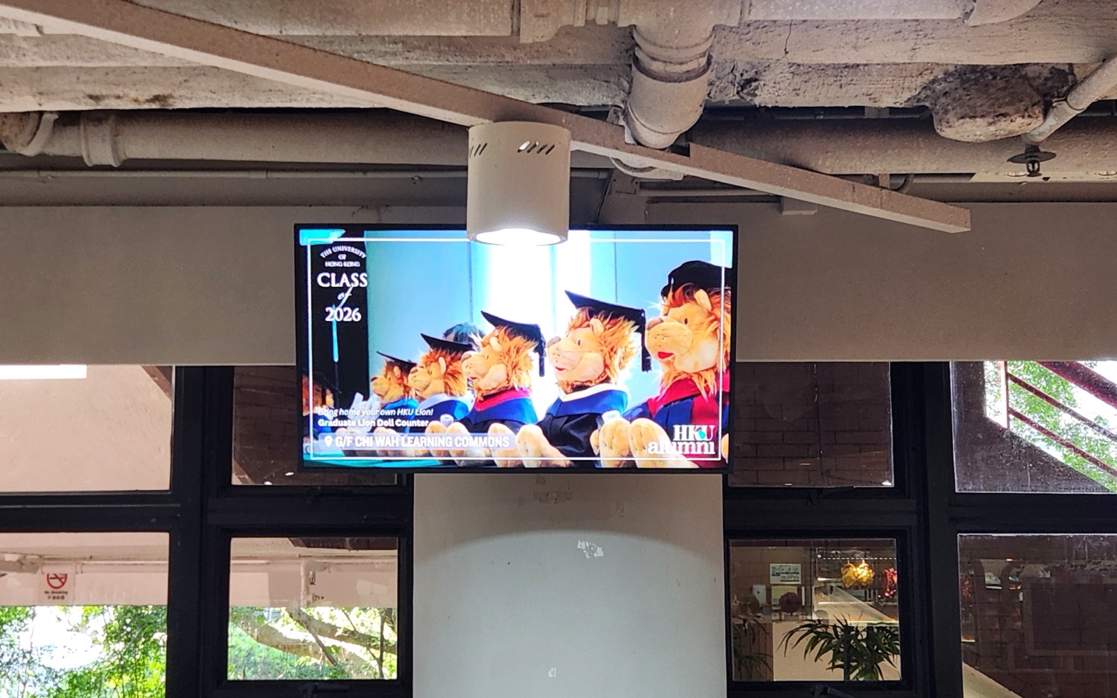 A U-Vision screen suspended beneath the ceiling services above the canteen seating in the Chong Yuet Ming Amenities Centre