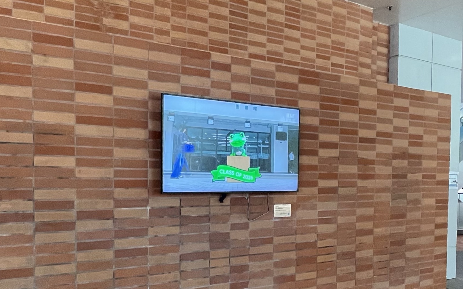 A U-Vision screen on the timber-clad lobby wall on the ground floor of Jockey Club Tower