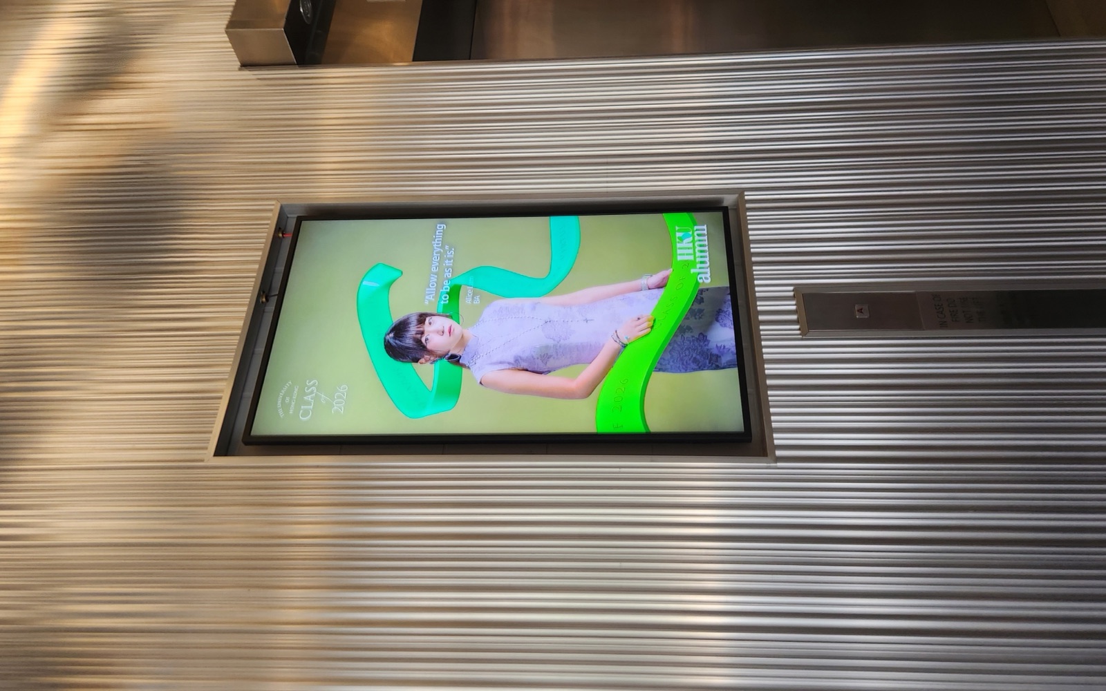 A U-Vision portrait screen above the lift lobby in K.K. Leung Building, beside the Hong Kong Biodiversity Museum signage