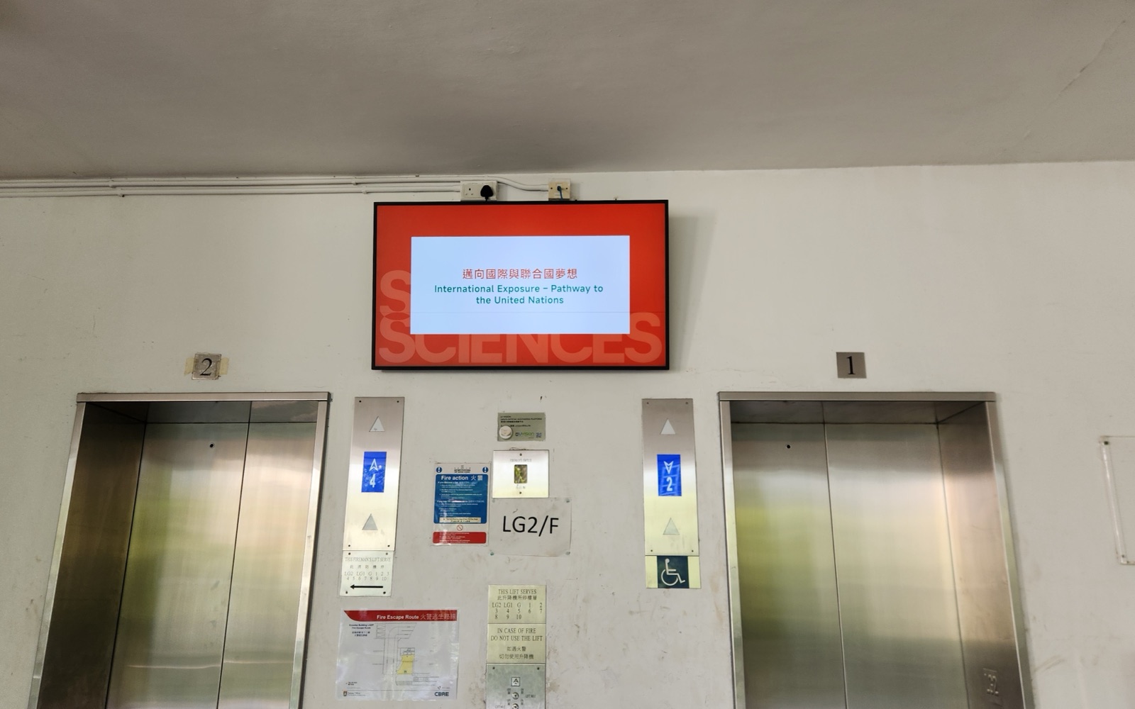 A U-Vision screen mounted above the lift lobby on the lower ground floor of Knowles Building