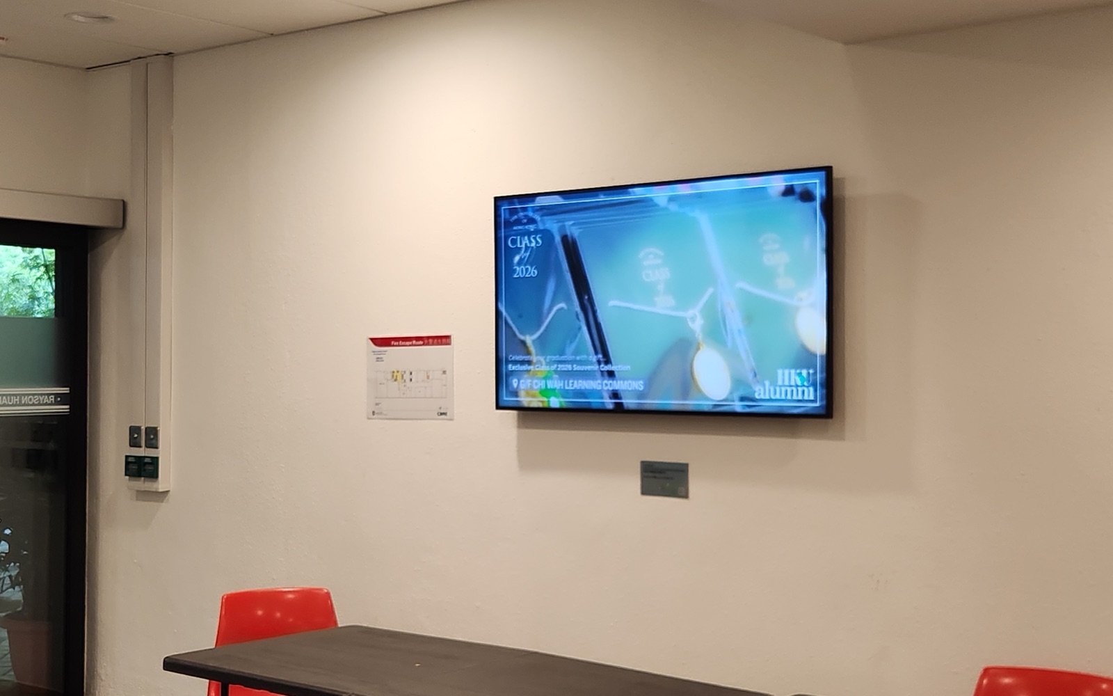 A U-Vision screen mounted on the lobby wall inside the entrance of the Rayson Huang Theatre